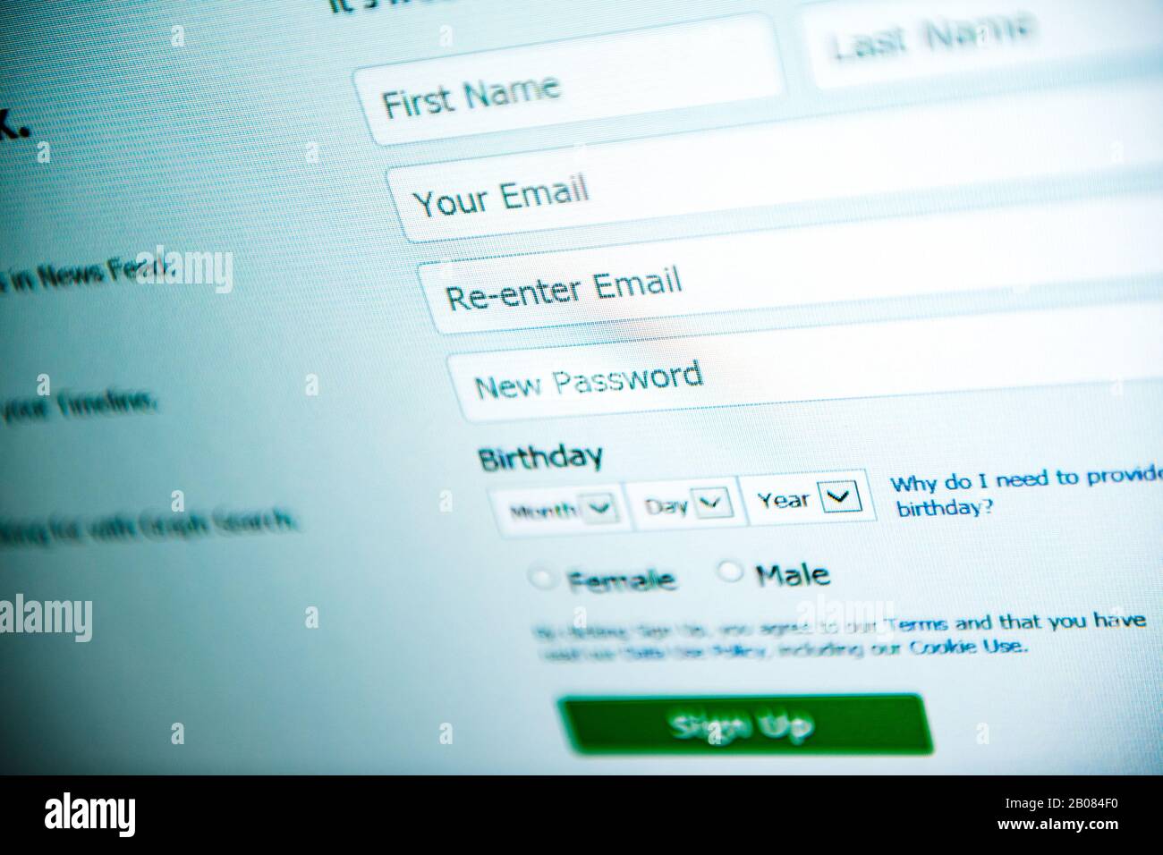 Londra, Regno Unito - 28 febbraio 2014: Modulo di iscrizione al social network modulo del sito Web di Facebook sullo schermo del computer e-mail e teleobiettivo tilt-shift utilizzato per l'accesso al telefono Foto Stock