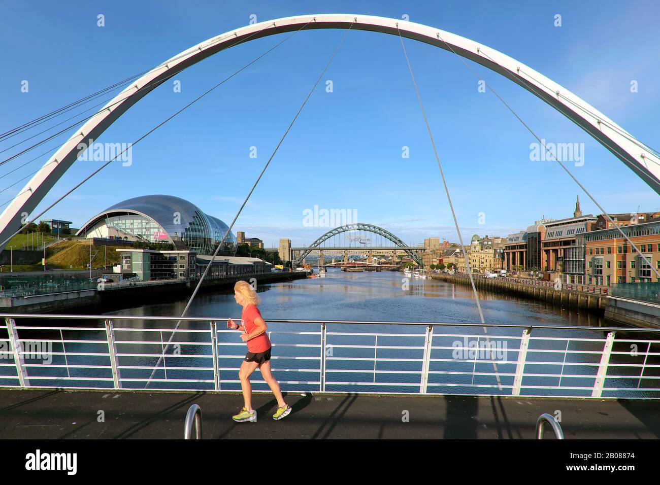 Jogger Femmina, Il Gateshead Millennium Bridge / Il Lampeggiante Eye Bridge E Sage Gateshead, Newcastle Upon Tyne, Tyne E Wear, Inghilterra, Regno Unito, Europa Foto Stock