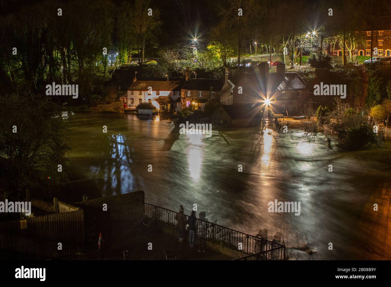 Ironbridge, Regno Unito. 18th Feb 2020. Mentre i livelli delle inondazioni sul fiume Severn hanno raggiunto il loro picco nelle prime ore di martedì 18th febbraio 2020, i residenti di Ironbridge hanno aspettato per vedere se le difese delle inondazioni resistessero alle 470 tonnellate al secondo di acqua che fluiva attraverso il sito patrimonio mondiale della Gola di Ironbridge. La lunga esposizione crea un effetto millstagno al torrente infuriante di vorticosi eddie che avevano già inondato numerose proprietà lungo il fiume Severn in Shropshire. Credito: Paul Bunch/Alamy Live News. Foto Stock