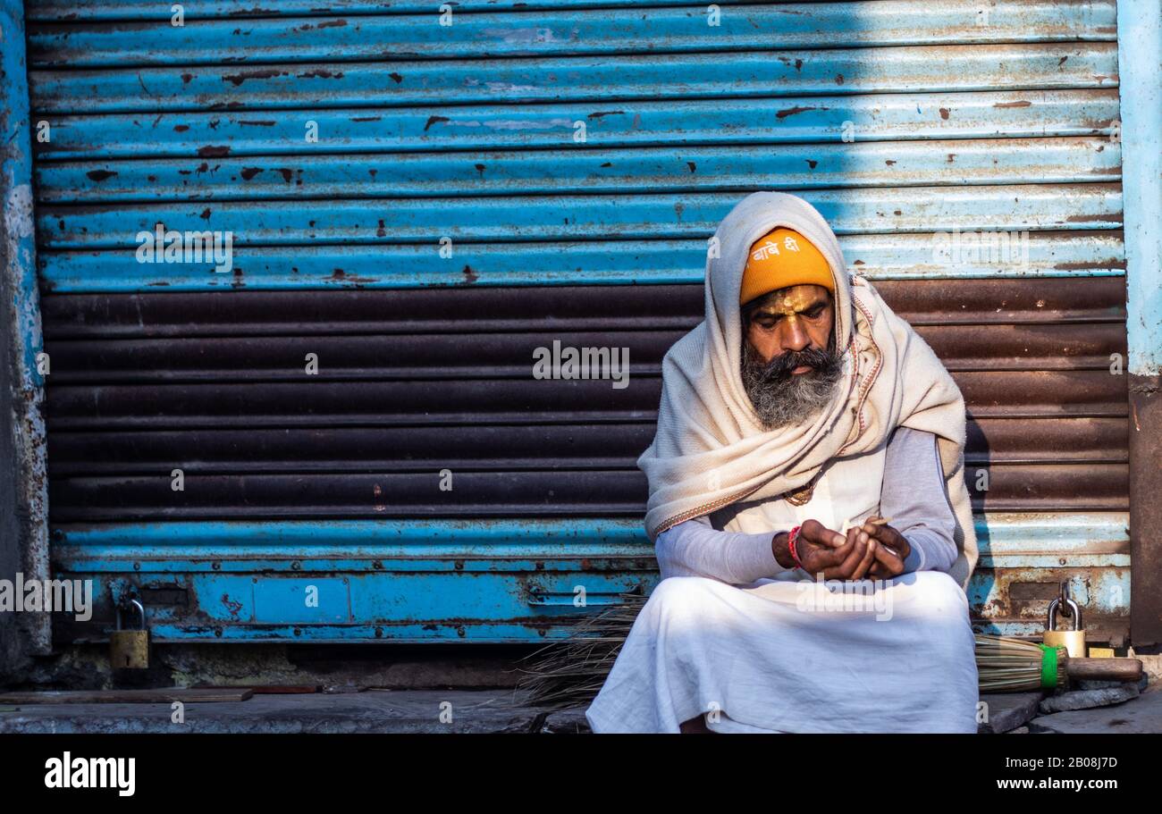 Pushkar, Rajasthan /India. 06 /11/2019. Indian Beggar per le strade del mattino presto che illumina il Cigaret Foto Stock