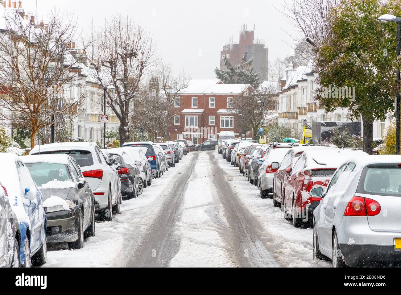 Strada terrazzata coperta di neve intorno alla zona di West Hampstead a Londra mentre nevica e nevica Foto Stock