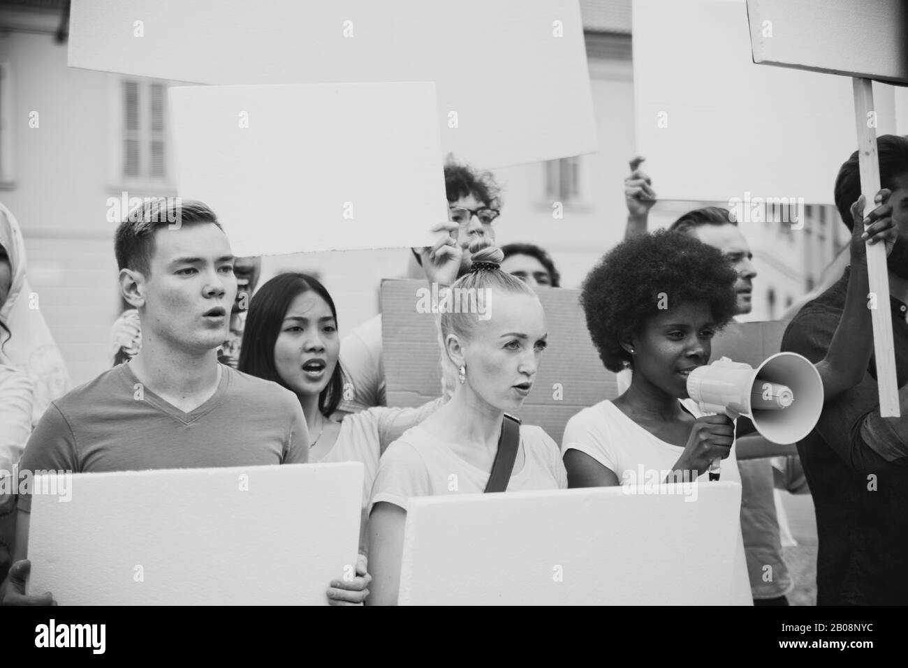 Manifestazione pubblica sulla strada contro i problemi sociali e i diritti umani. Gruppo di persone multietniche che fanno protesta pubblica Foto Stock