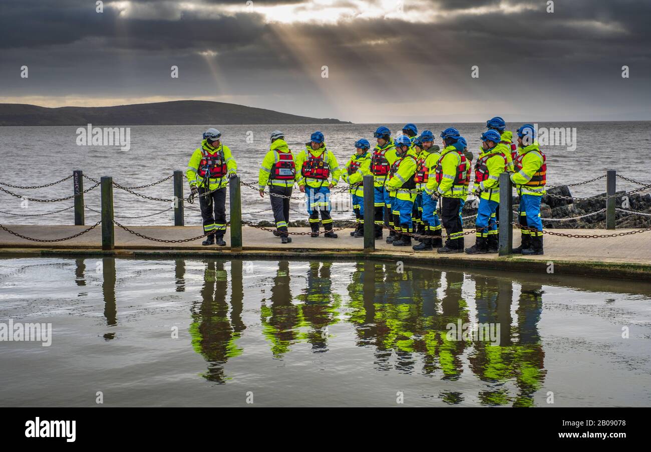 Guardia costiera membri di salvataggio durante un esercizio di formazione sul mare parete a Lago Marino a Weston Super Mare. Foto Stock