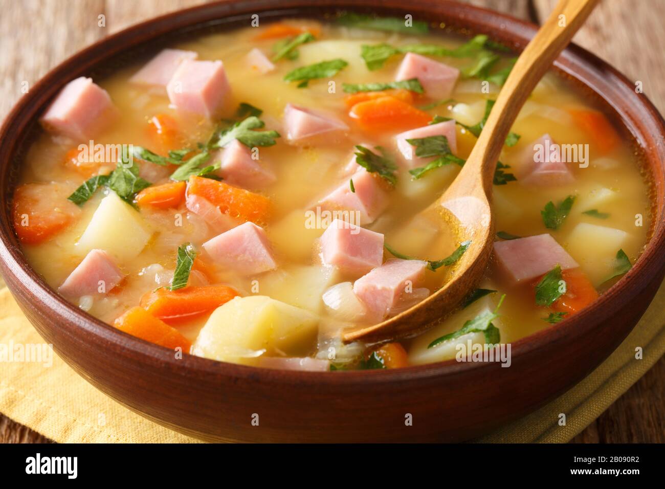 Zuppa di piselli spezzati a cottura lenta con verdure e prosciutto da vicino in una ciotola sul tavolo. Orizzontale Foto Stock