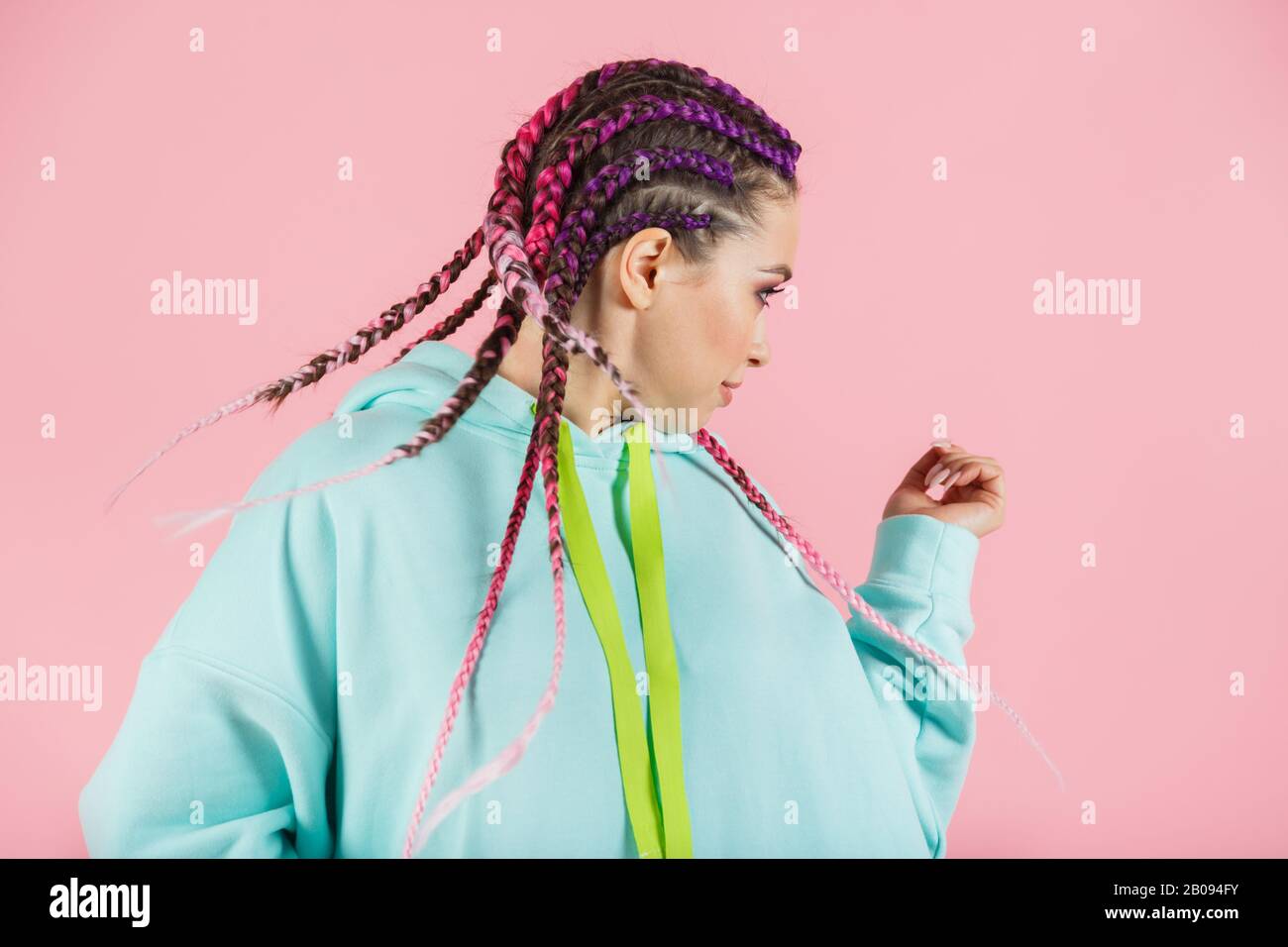Una ragazza con un set alla moda di trecce multicolore Kanekalon. Ciocche artificiali colorate di capelli. Foto Stock
