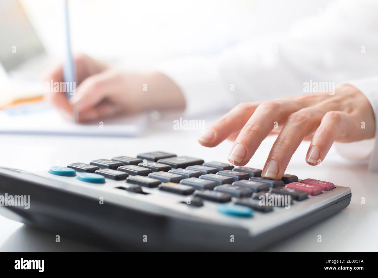 Il finanziatore considera il rapporto sulla calcolatrice. Foto Stock