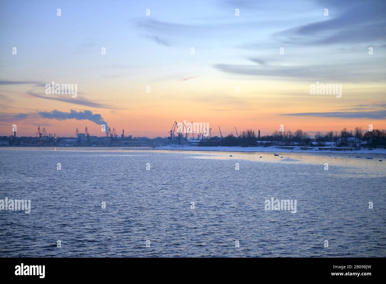 Inverno Pink tramonto e vista del paesaggio urbano sul Mar Baltico. Tramonto con massi innevati e paesaggio di spiaggia. Mar Baltico, inverno Foto Stock