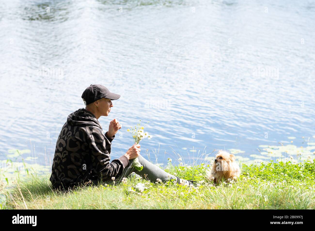 Una donna con un cane sul lago in estate. Foto Stock