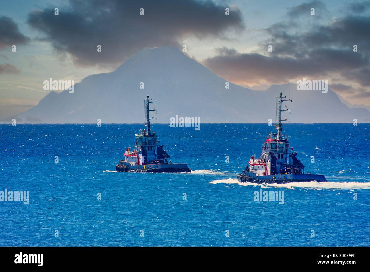 Due Rimorchiate Che Si Dirigono Verso Il Mare Verso Hazy Hills Foto Stock