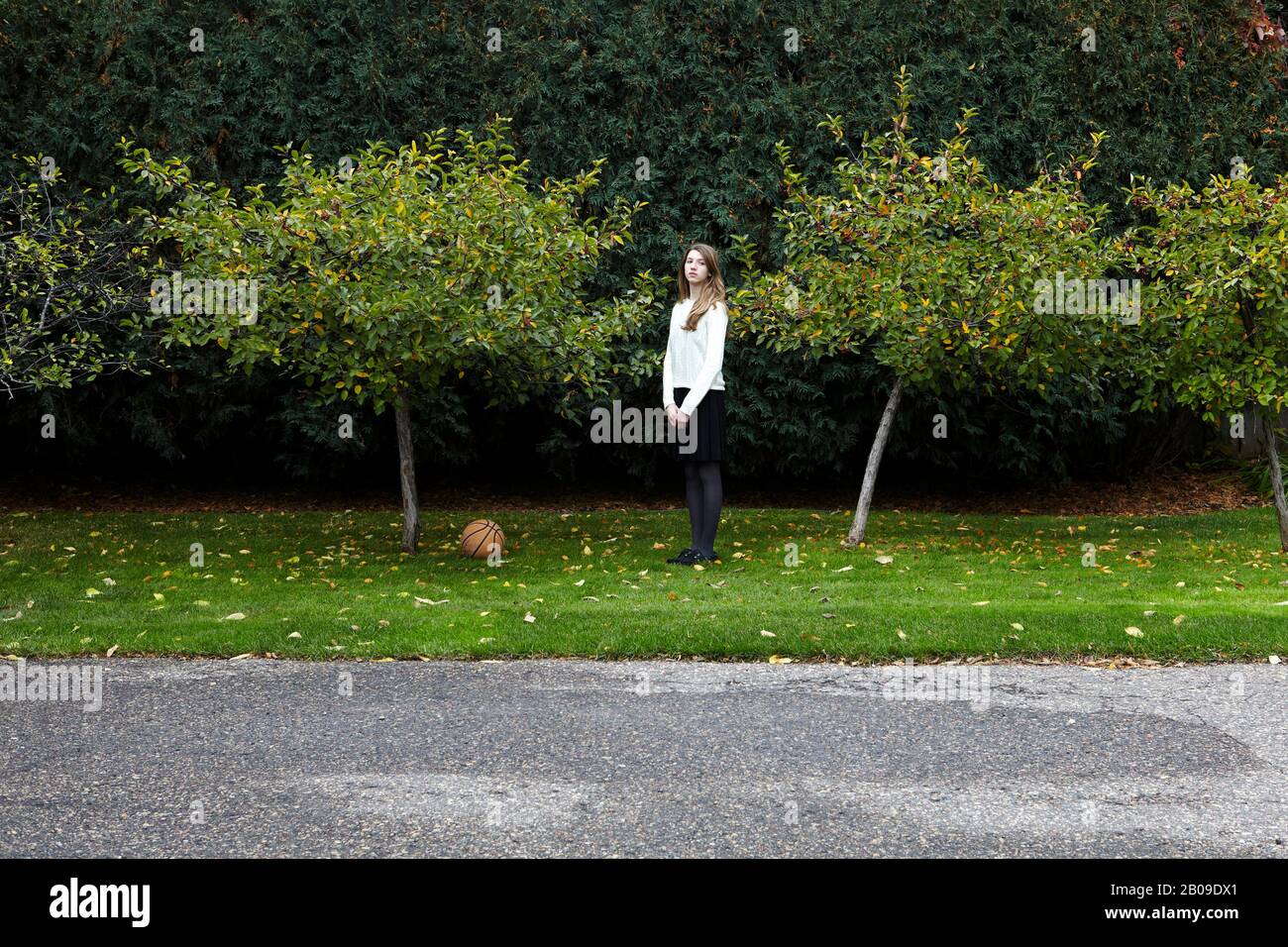 ragazza che gioca a basket dopo la scuola Foto Stock