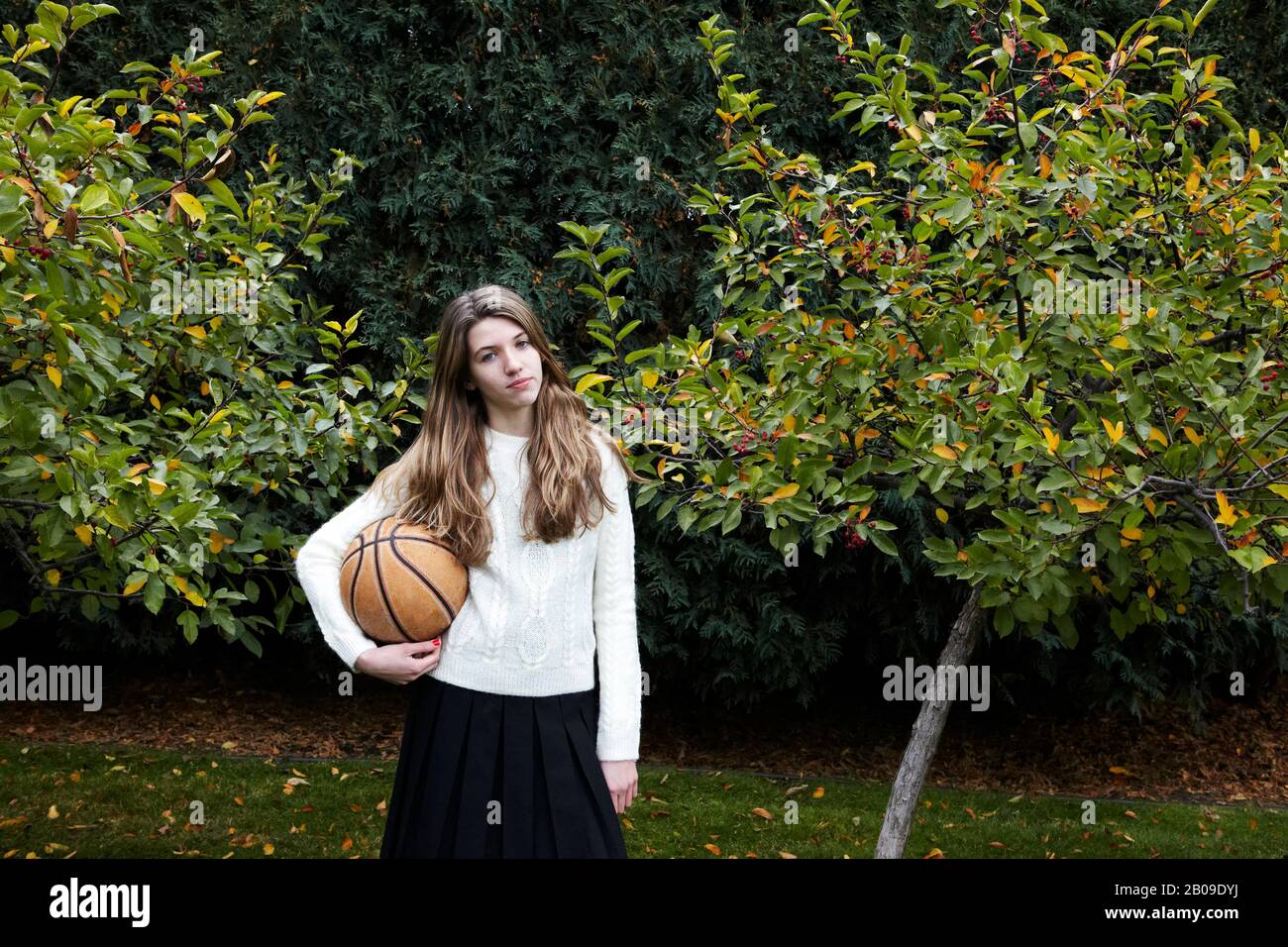 ragazza che gioca a basket dopo la scuola Foto Stock