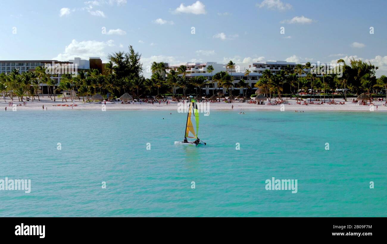Vela nel Mar dei Caraibi al largo delle rive di Punta Cana, Repubblica Dominicana, vacanza di lusso e resort di vacanza sullo sfondo, con sabbia bianca Foto Stock