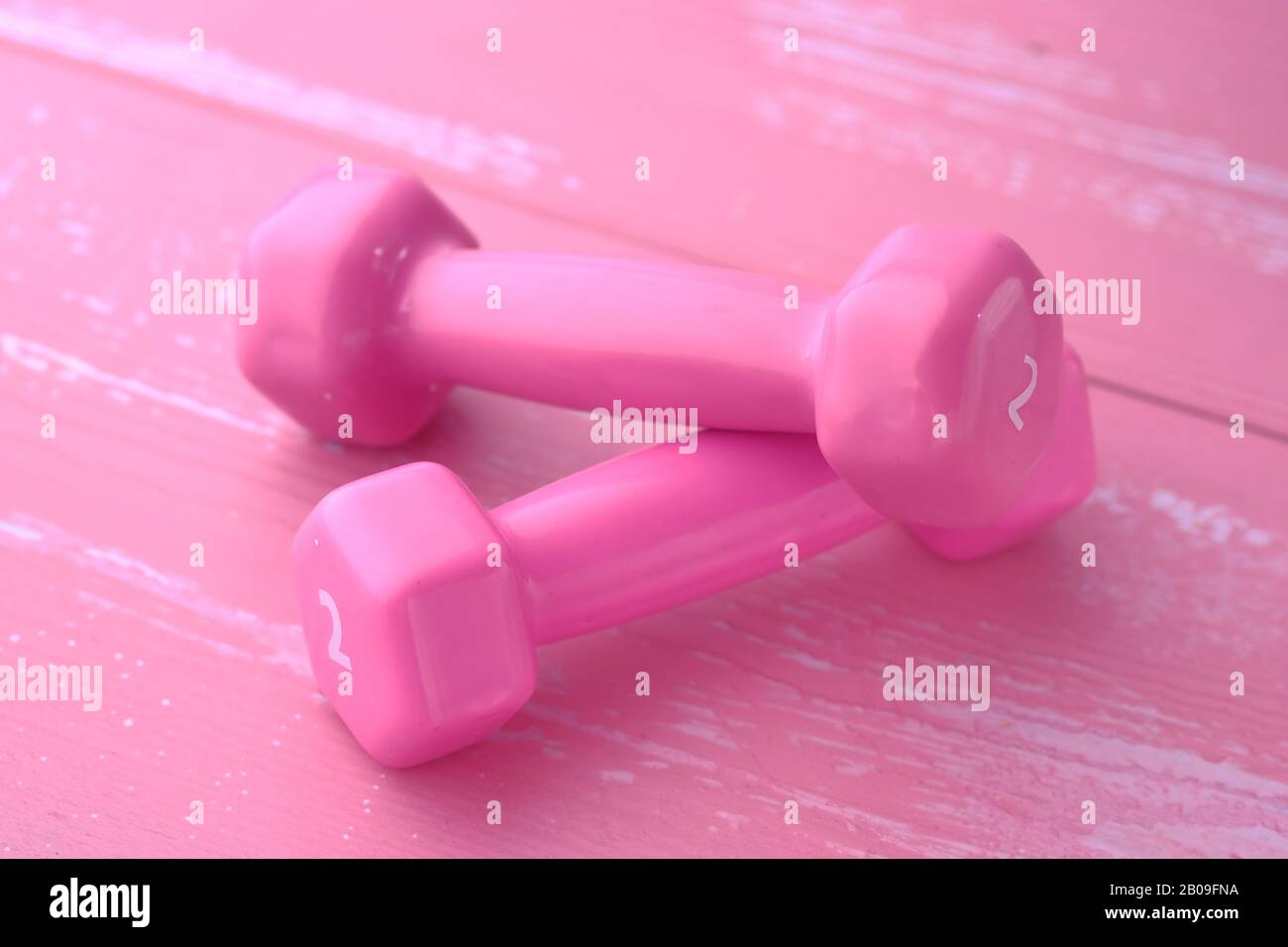 Primo piano di colore rosa dumbbell sul tavolo Foto Stock