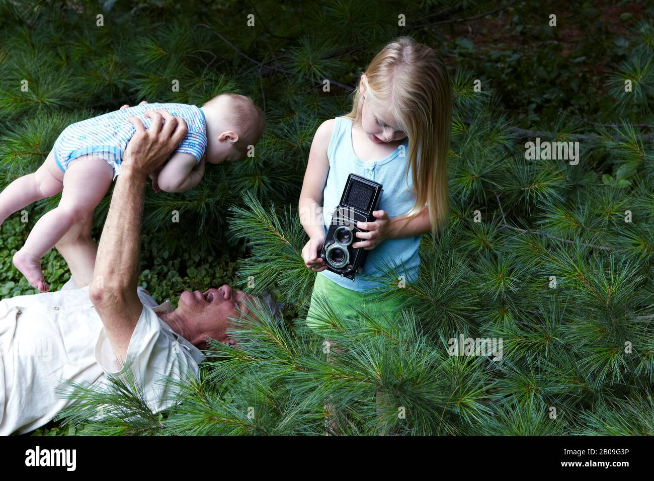 nonno insegnava a sua figlia a usare la fotocamera a doppia lente d'epoca Foto Stock