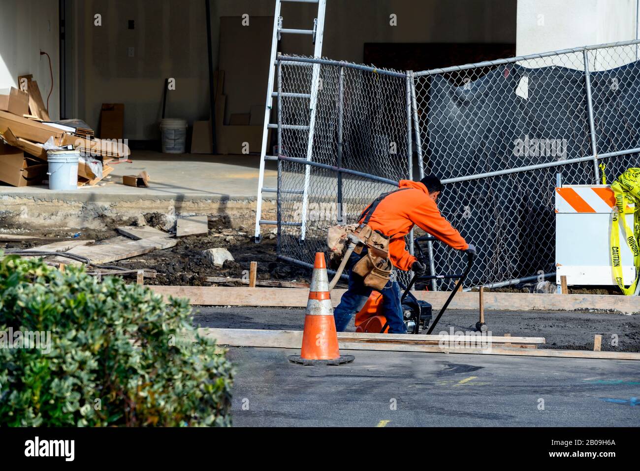 Imprese edili in cemento che installano una canalina di drenaggio per marciapiedi, marciapiedi e temporali su una nuova costruzione della casa. Foto Stock