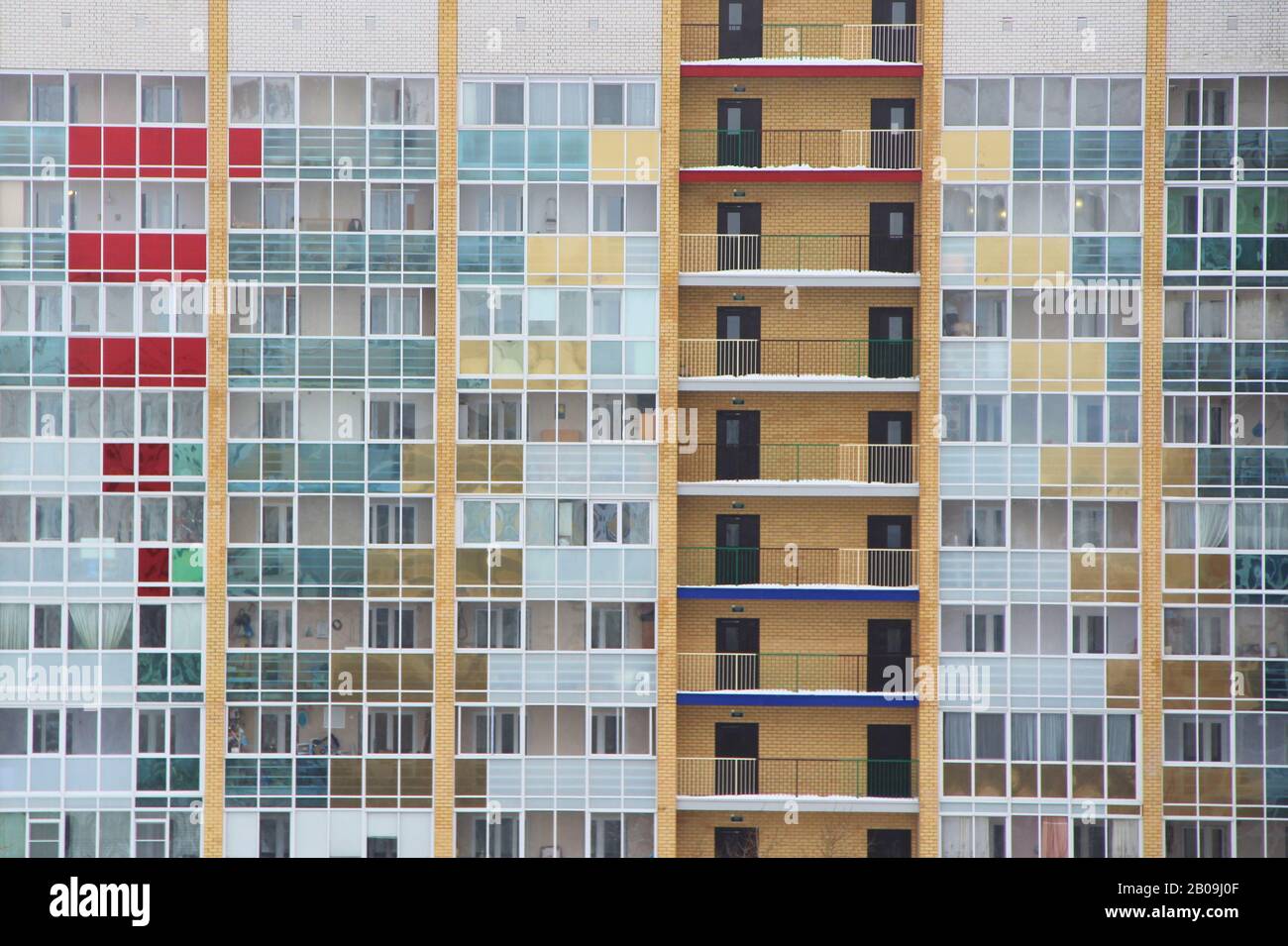 Parete di una moderna casa piastrellata in mattoni con file di finestre e vetrate colorate. Stock foto per web, stampa, sfondo e sfondo, con spazio vuoto per il testo Foto Stock