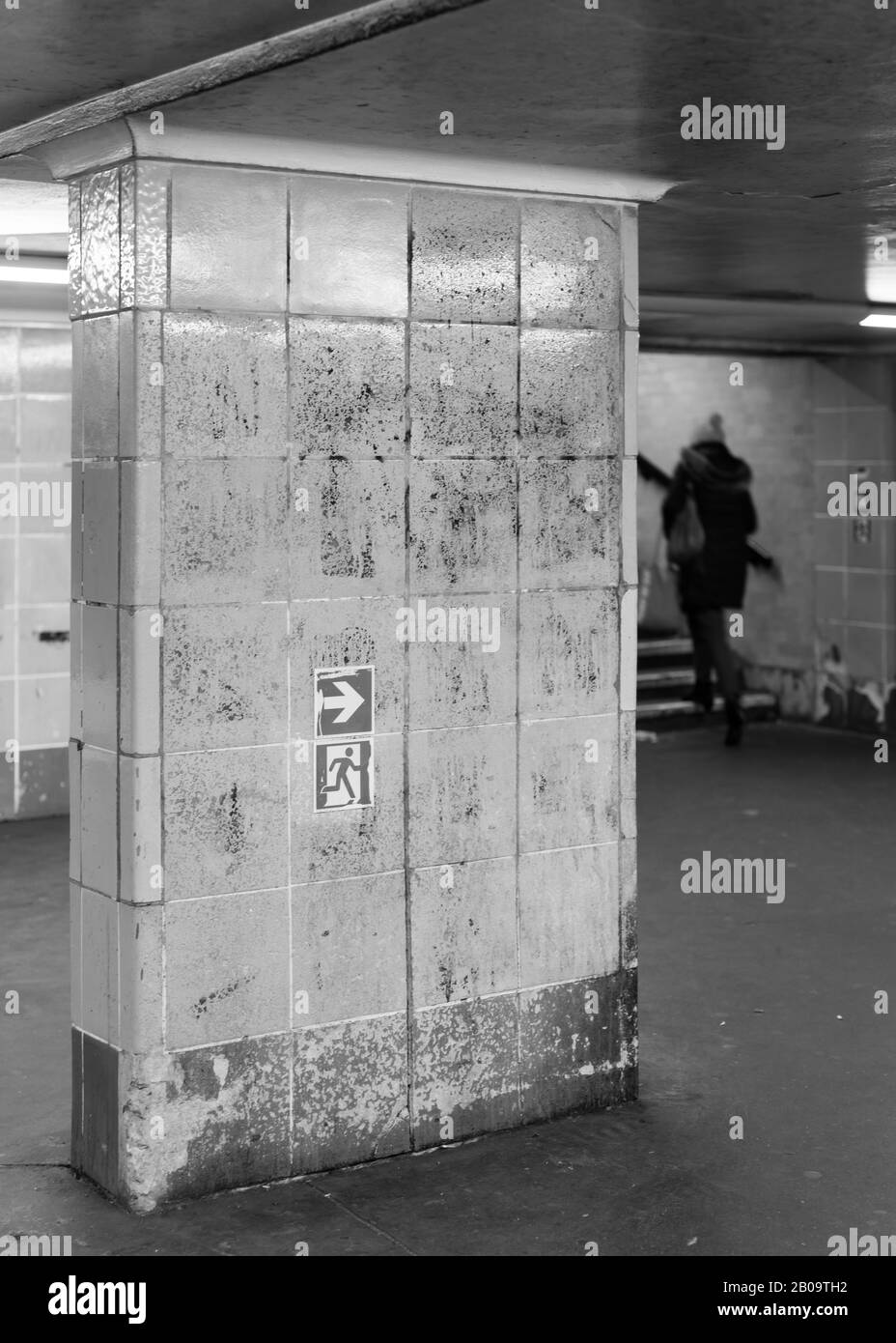 Un pedone su una scala nella stazione della metropolitana Foto Stock