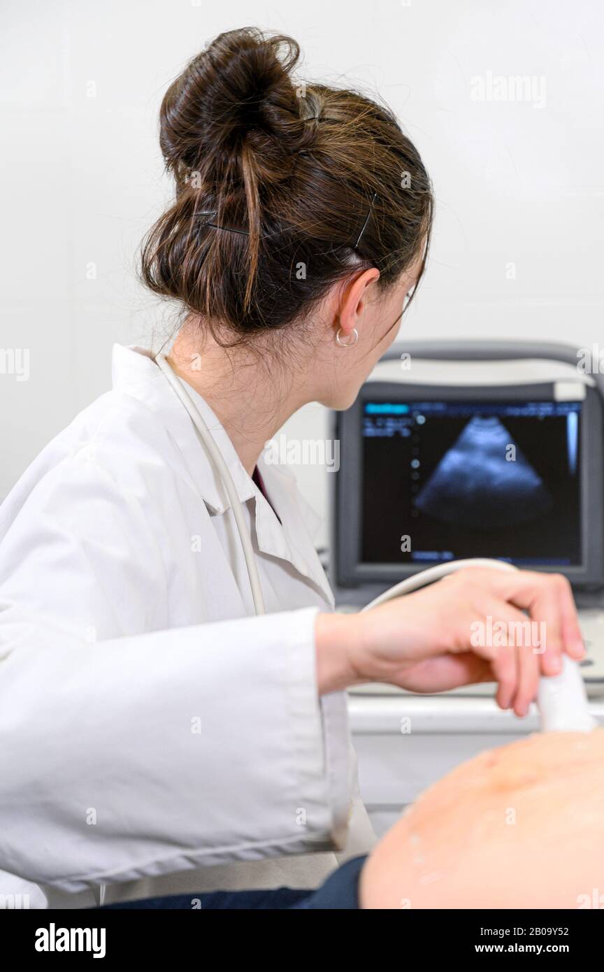 Il medico esegue l'ecografia o La procedura Di Ecografia a una donna In Gravidanza in ospedale, primo piano Shot del Trasduttore In Movimento Ostetricia sul ventre della Futura Madre . Foto Stock