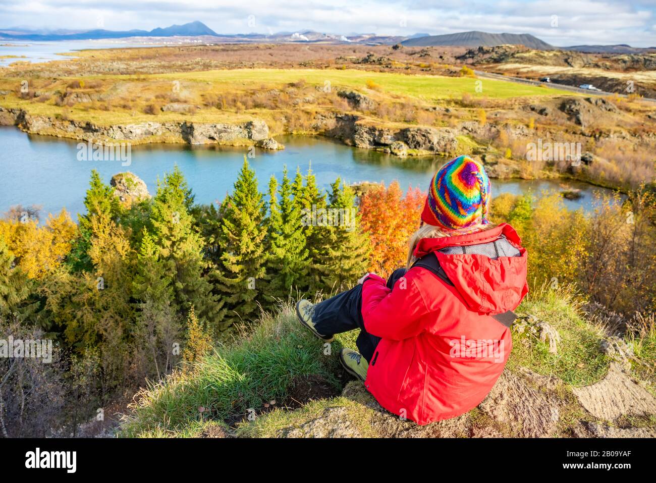 Donna sportiva ammira il lago Myvatn nel nord dell'Islanda. Tranquillo paesaggio autunnale. Famosa attrazione turistica. Foto Stock