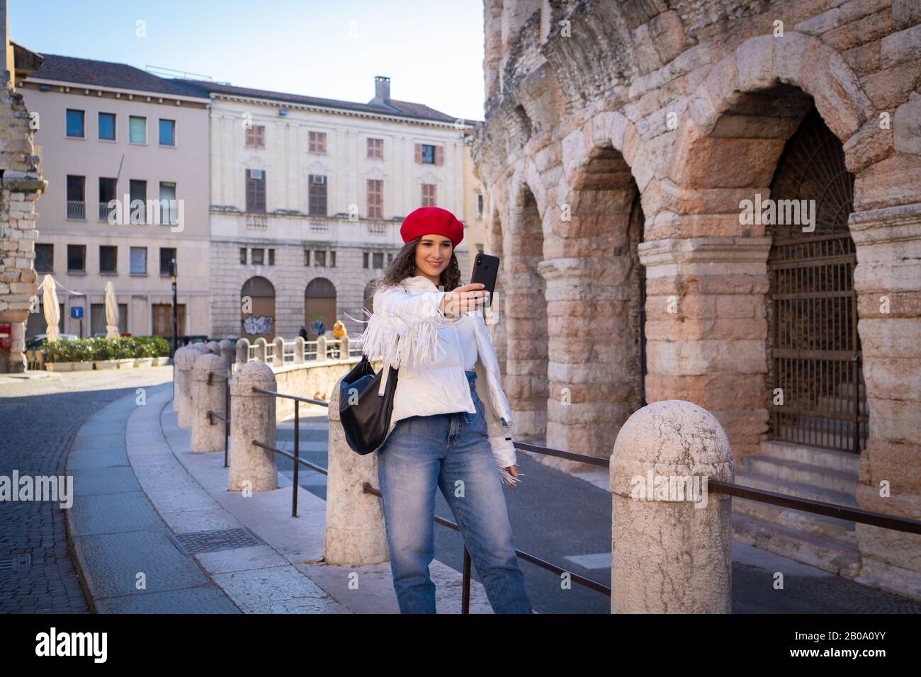 Elegante donna turistica scattare una foto di fronte all'anfiteatro, l'antichità, l'europa Foto Stock