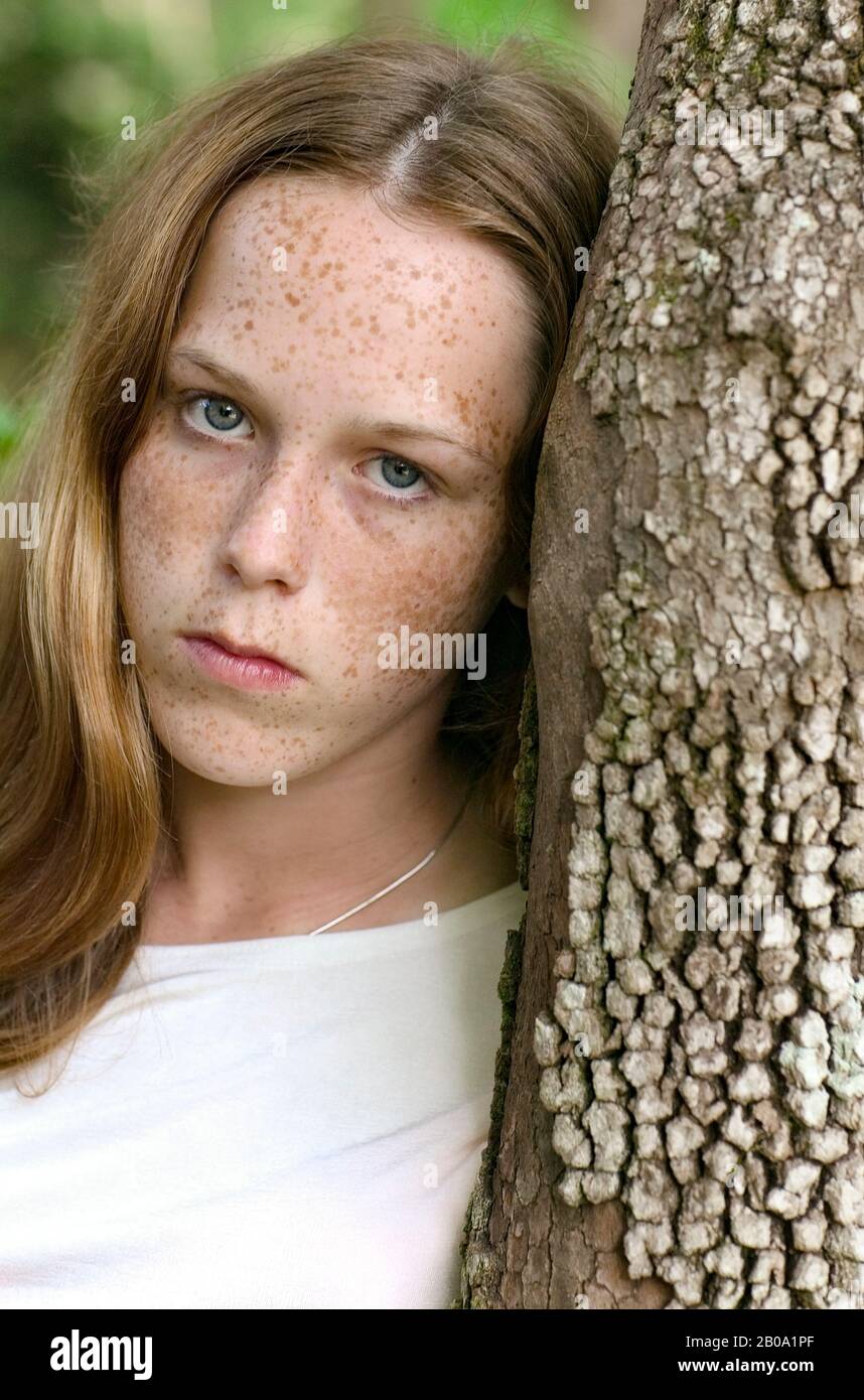 Una giovane ragazza giovane 14 anni, con occhi blu, capelli rossi, pelle discreta e frate. Foto Stock