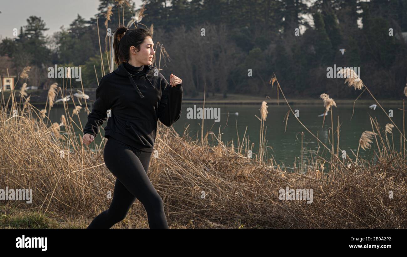 donna che corre su una riva del fiume, copia spazio Foto Stock