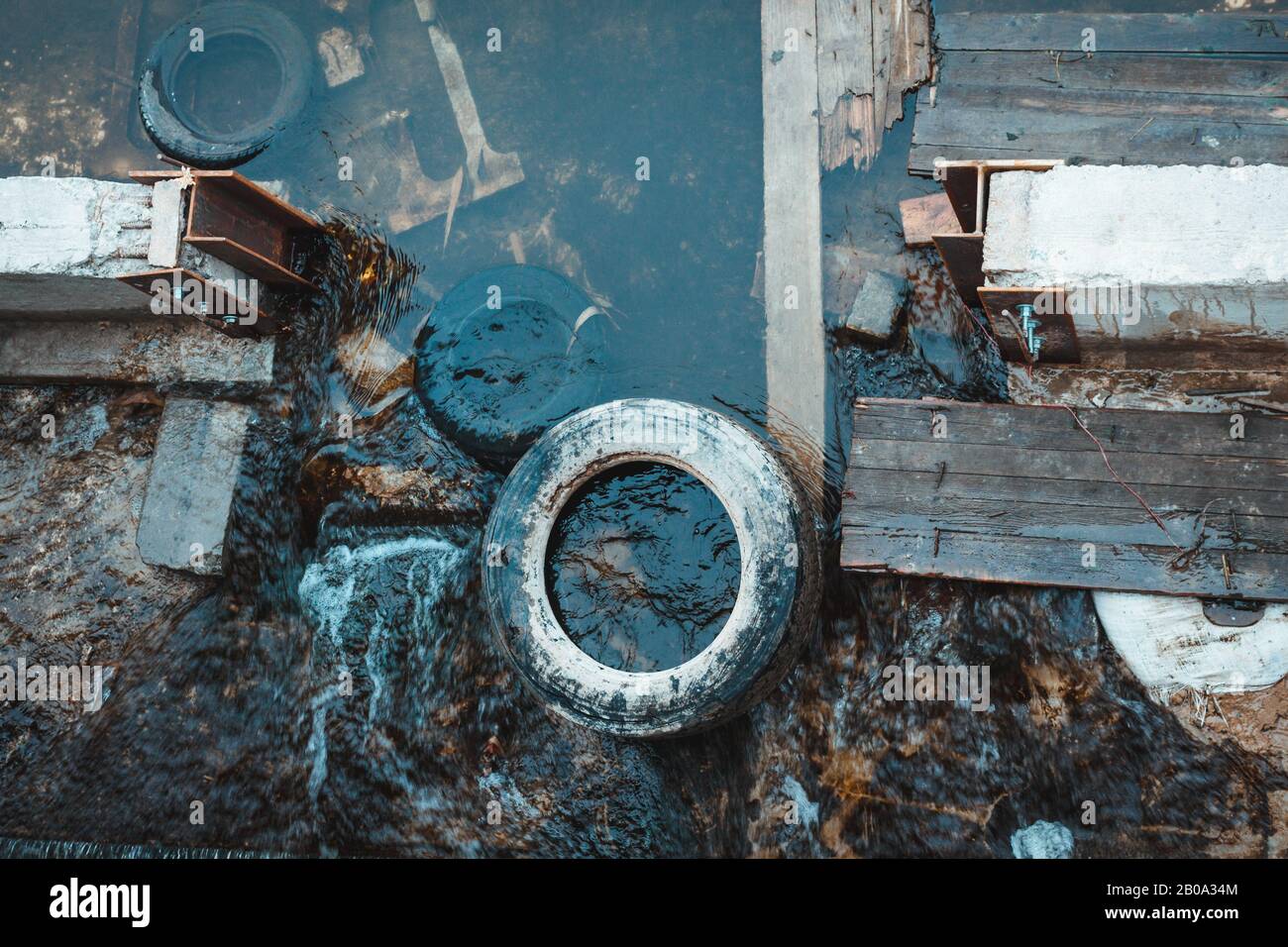 Inquinamento dell'acqua con congestione nel letto del fiume. Problema globale dell’immondizia urbana. Conservazione ambientale. Inquinamento globale sfondo orizzontale. Problema ambientale. Acqua bloccata dai detriti degli pneumatici. Foto Stock