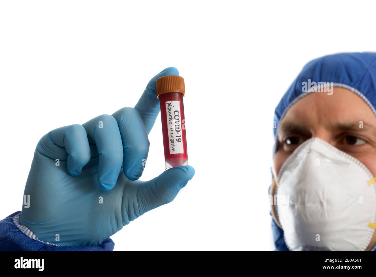 Medico in abbigliamento protettivo che guarda il campione di sangue Foto Stock