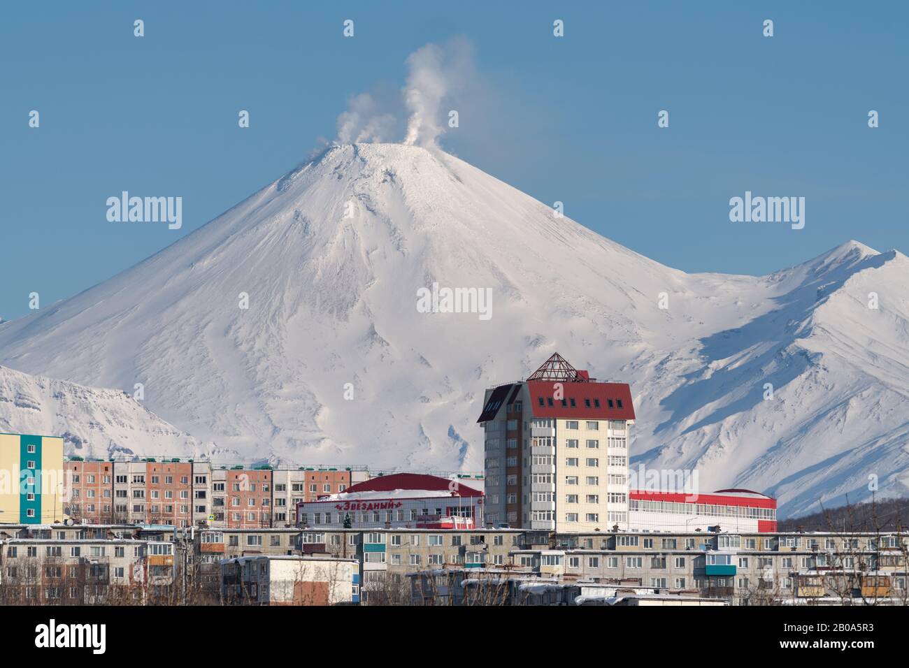 Paesaggio urbano invernale di Petropavlovsk-Kamchatsky City, fumaroles attività di Avachinsky Volcano tempo soleggiato con cielo limpido. Città Di Petropavlovsk Foto Stock