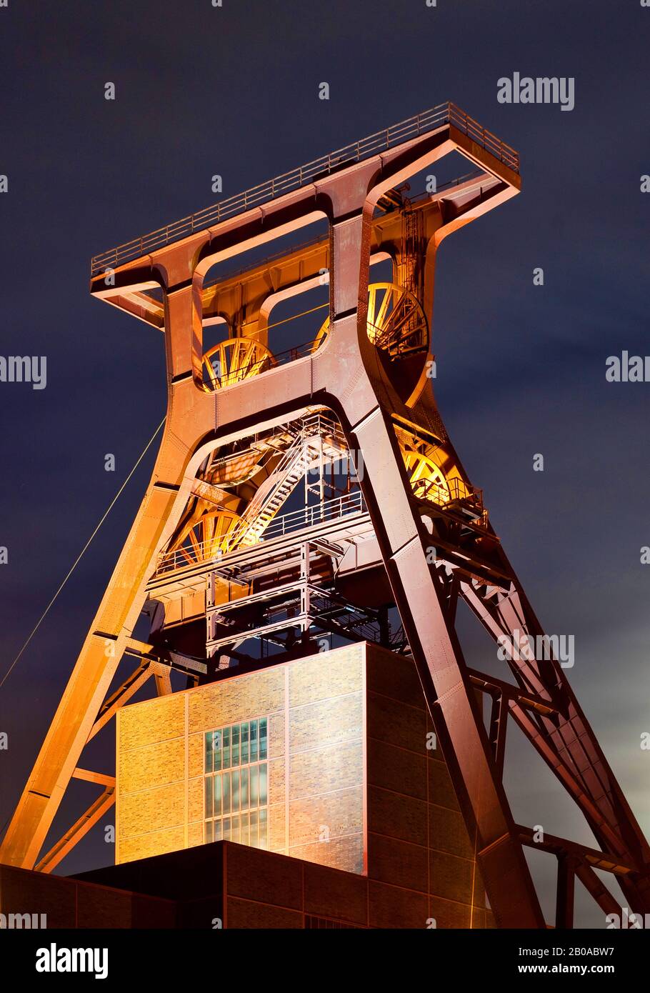 Copricapo illuminato di Schacht XII del Complesso industriale della miniera di carbone di Zollverein in serata, Germania, Renania settentrionale-Vestfalia, zona della Ruhr, Essen Foto Stock