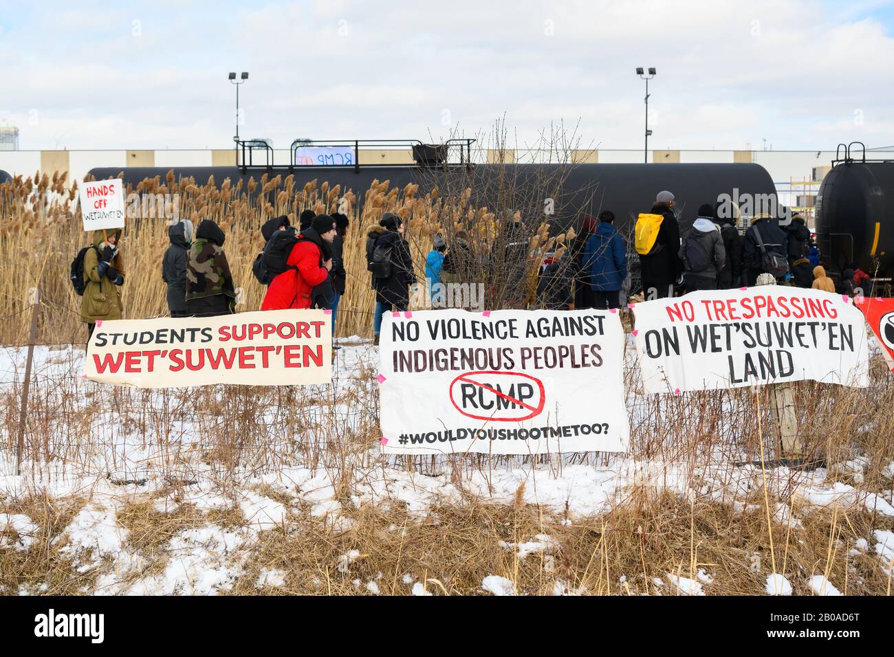 I manifestanti anti anti-pipeline si preparano a attraversare una linea ferroviaria bloccata in solido con il popolo Wet'suwet'en come parte delle proteste di Shut Down Canada. Foto Stock