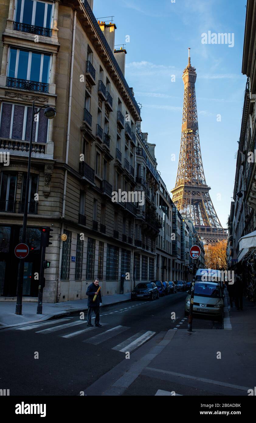 Un francese cammina davanti alla Torre Eiffel a Parigi con una baguette. Foto Stock