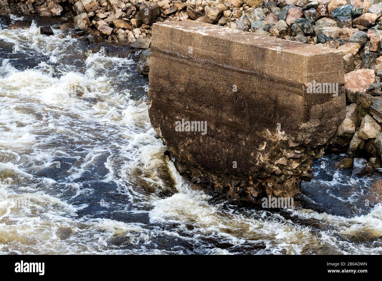 Un supporto eroso per un vecchio ponte. Il ponte è andato, rimane solo il supporto. L'erosione è grave. Foto Stock
