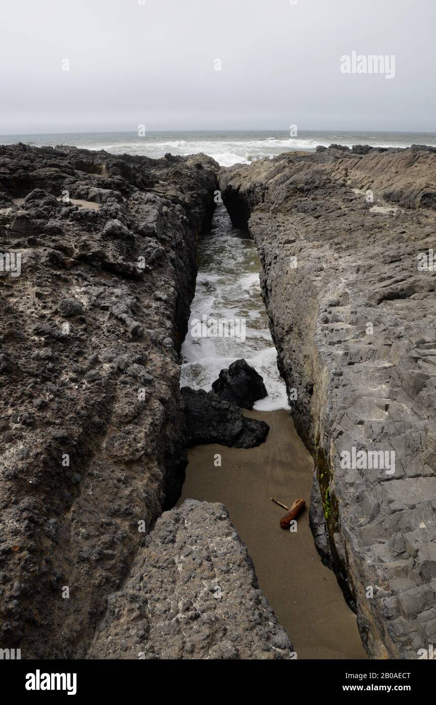 Canale stretto tagliato nella roccia al bordo degli oceani, Cape Perpetua, Oregon. Foto Stock