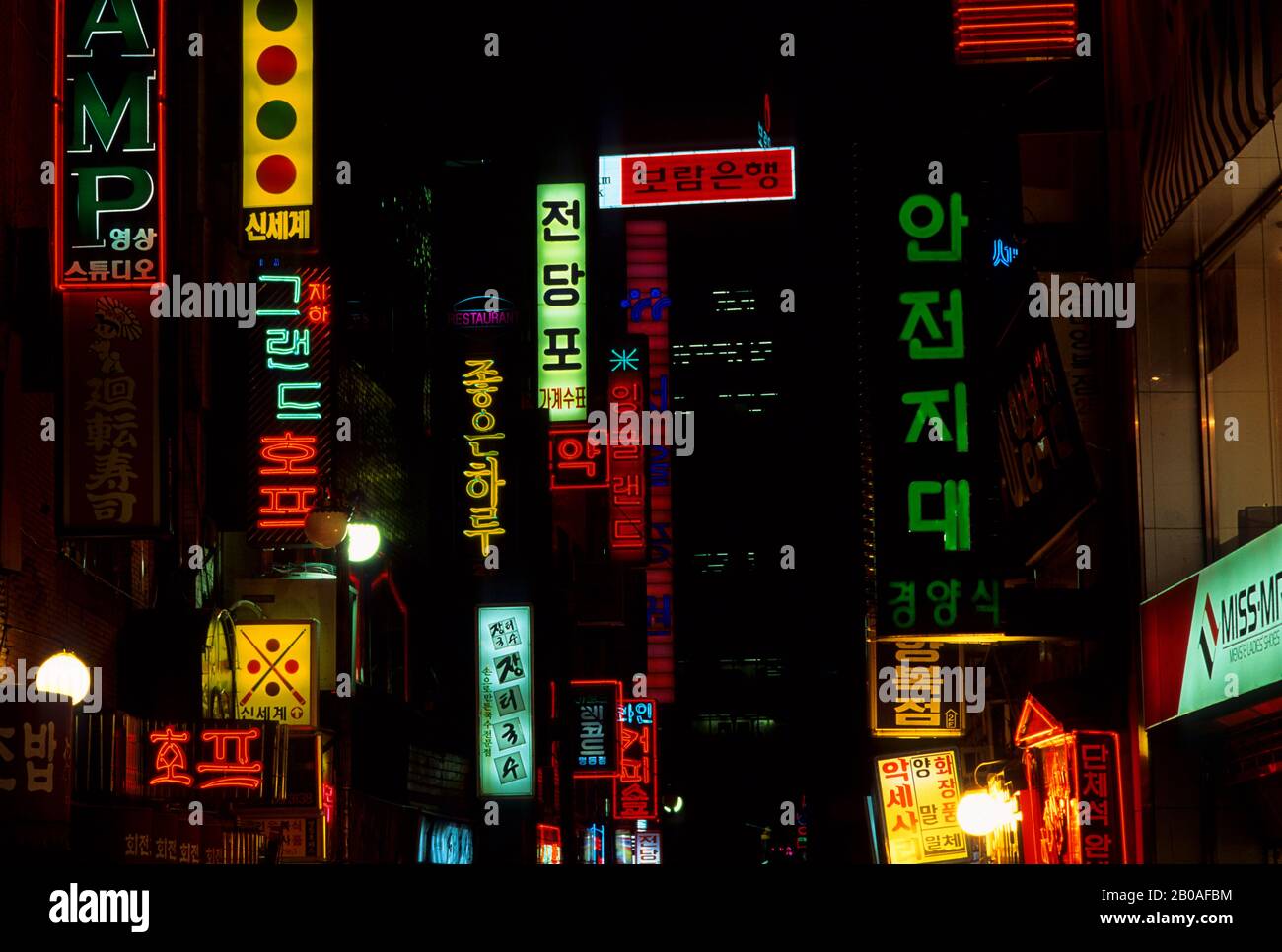 COREA, SEOUL, L'AREA DELLO SHOPPING DI MYUNG-DONG DI NOTTE CON COLORATE INSEGNE AL NEON Foto Stock