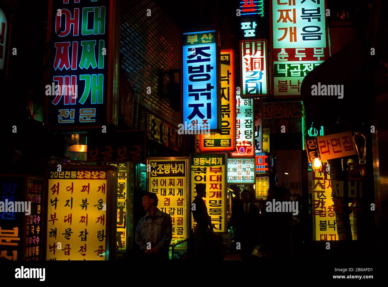 COREA, SEOUL, L'AREA DELLO SHOPPING DI MYUNG-DONG DI NOTTE CON COLORATE INSEGNE AL NEON Foto Stock
