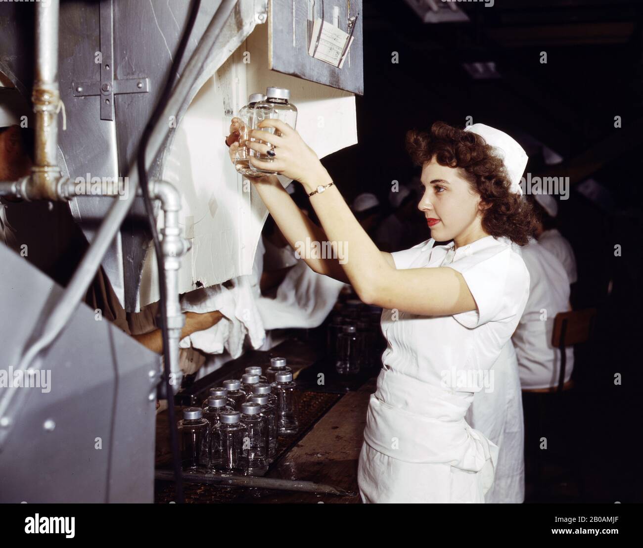 Lavoratore di Produzione di guerra femminile con bottiglie Di Donatore Trasfusionale, Baxter Laboratories, Glenview, Illinois, USA, fotografia di Howard R. Hollem, U.S. Office of War Information, ottobre 1942 Foto Stock