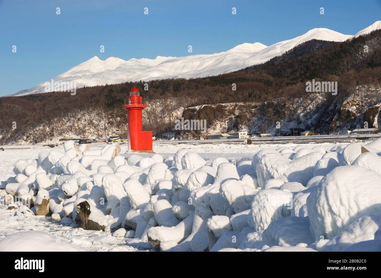GIAPPONE, ISOLA DI HOKKAIDO, PENISOLA DI SHIRETOKO, PORTO UTORO, FARO ROSSO CON MONTAGNE SULLO SFONDO Foto Stock