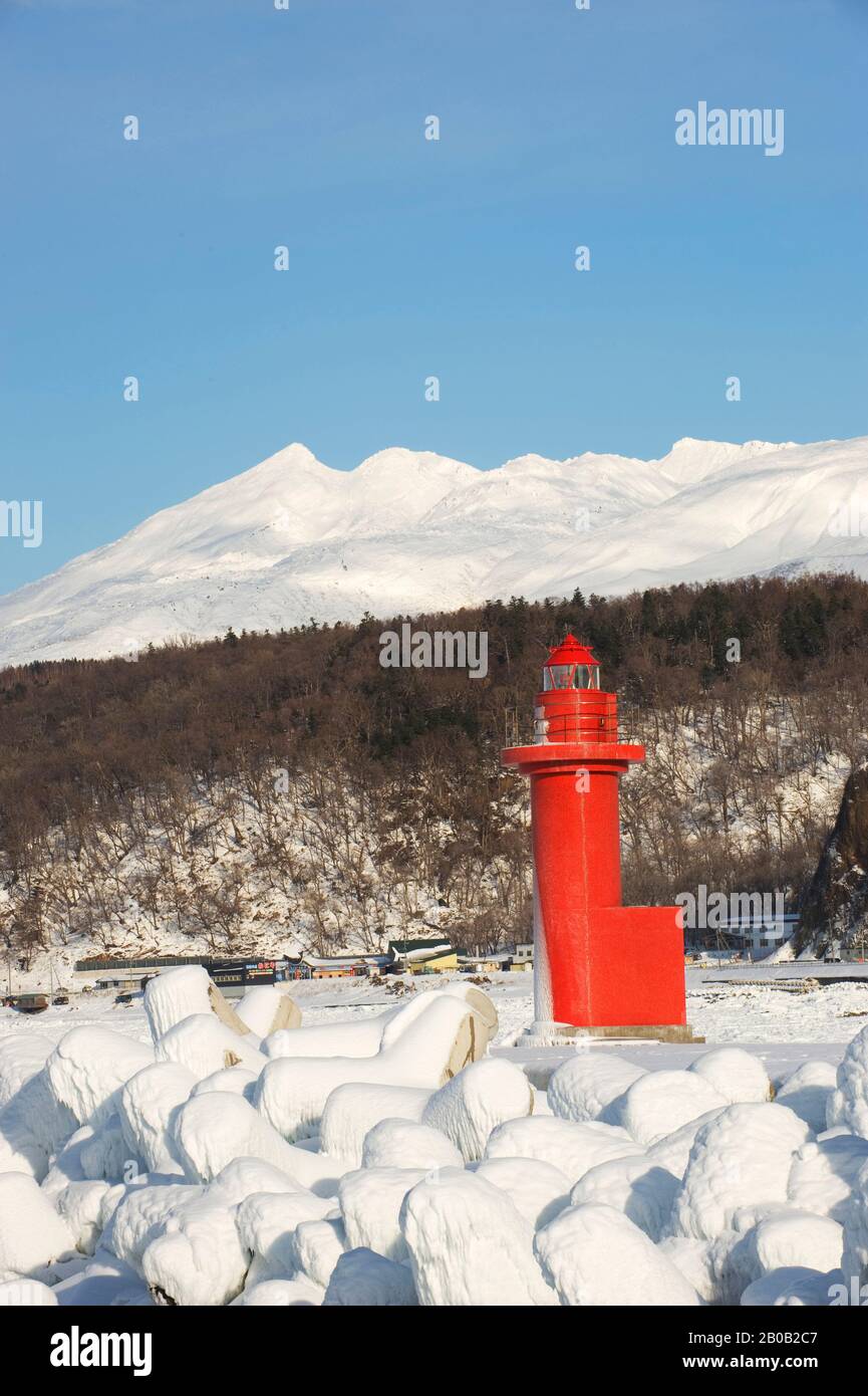 GIAPPONE, ISOLA DI HOKKAIDO, PENISOLA DI SHIRETOKO, PORTO UTORO, FARO ROSSO CON MONTAGNE SULLO SFONDO Foto Stock