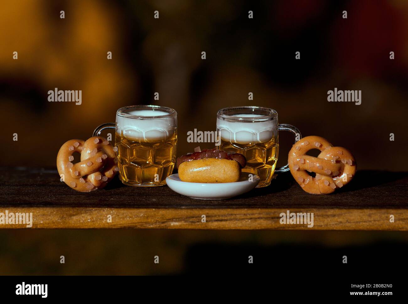 Due Birre, Pretzels, Salsiccia Su Tavola Di Legno Foto Stock