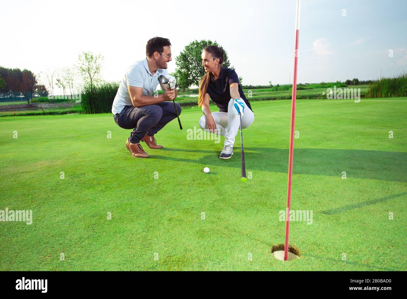 Due golfisti stanno flirtare sul campo da golf. Foto Stock