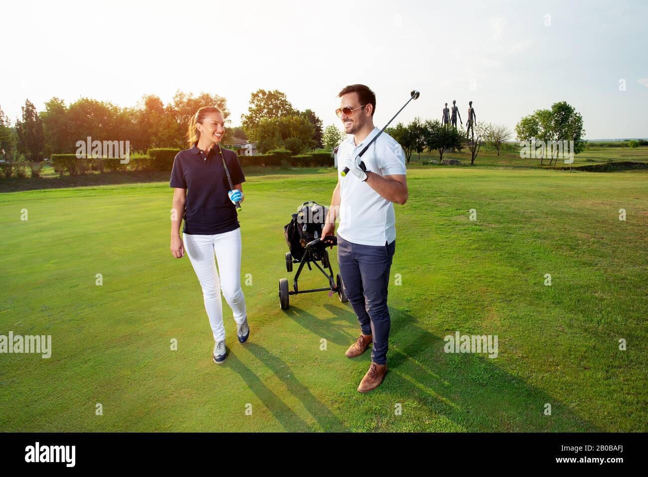 Una coppia attraente di golfers sono su un campo da golf. Foto Stock