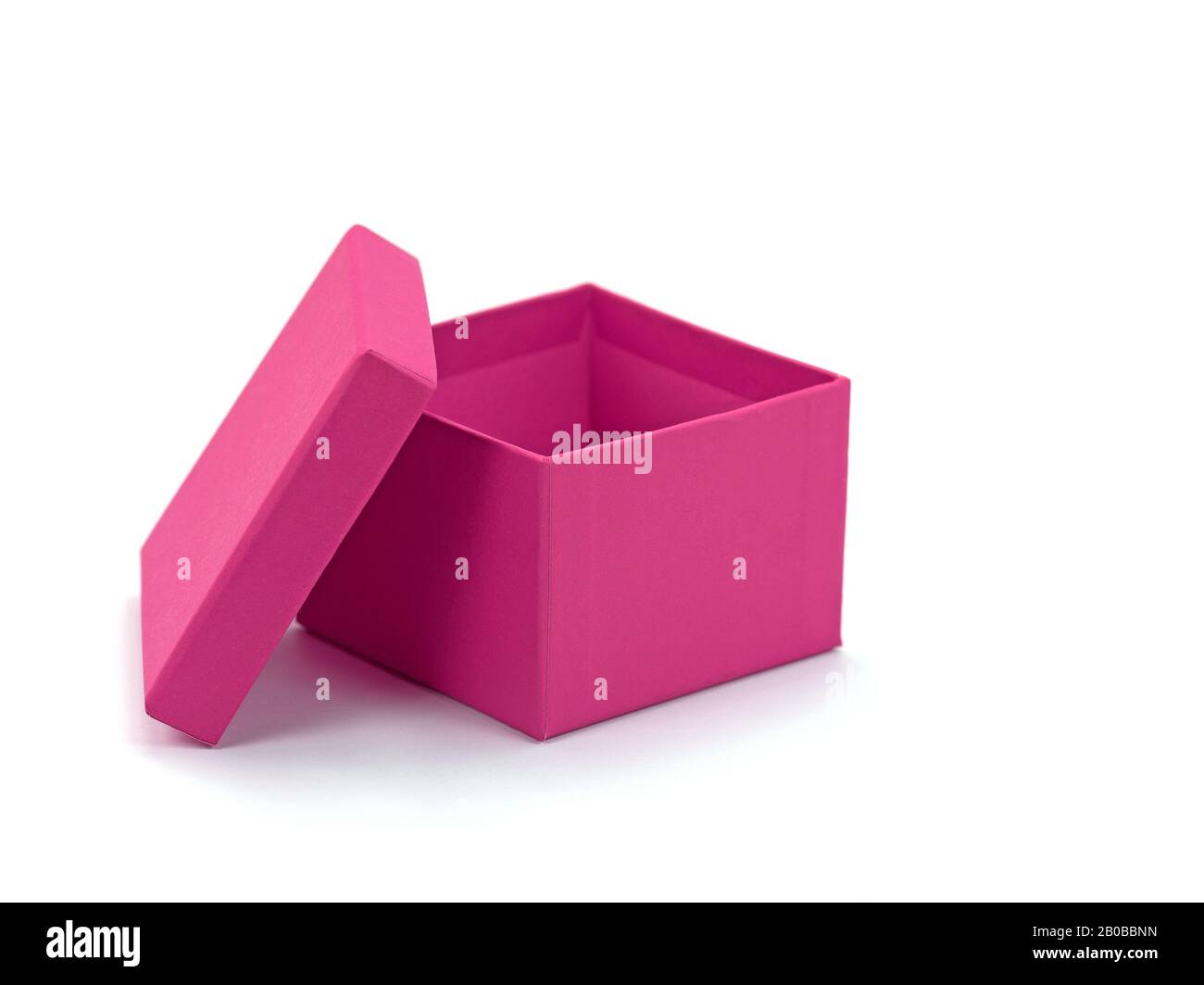 Scatola di cartone rosa vuota davanti a sfondo bianco Foto Stock