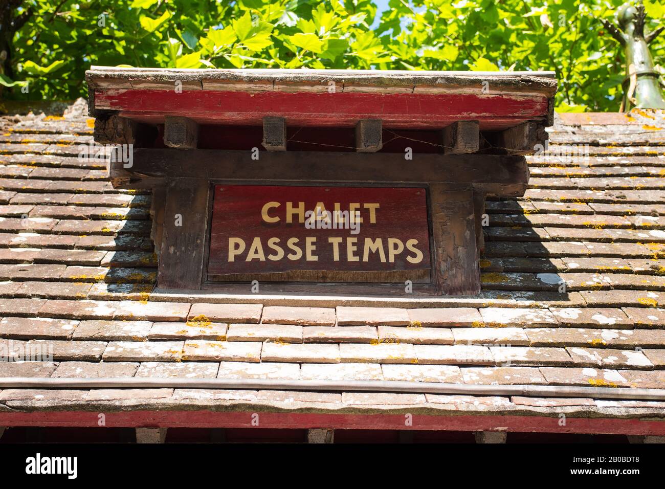 Cartello "Chalet passe-temps", Cabourg, Nomandy. Francia. Luglio 2019. Bel nome su un tipico tetto francese. Giornata estiva con un lussuoso sfondo naturale Foto Stock