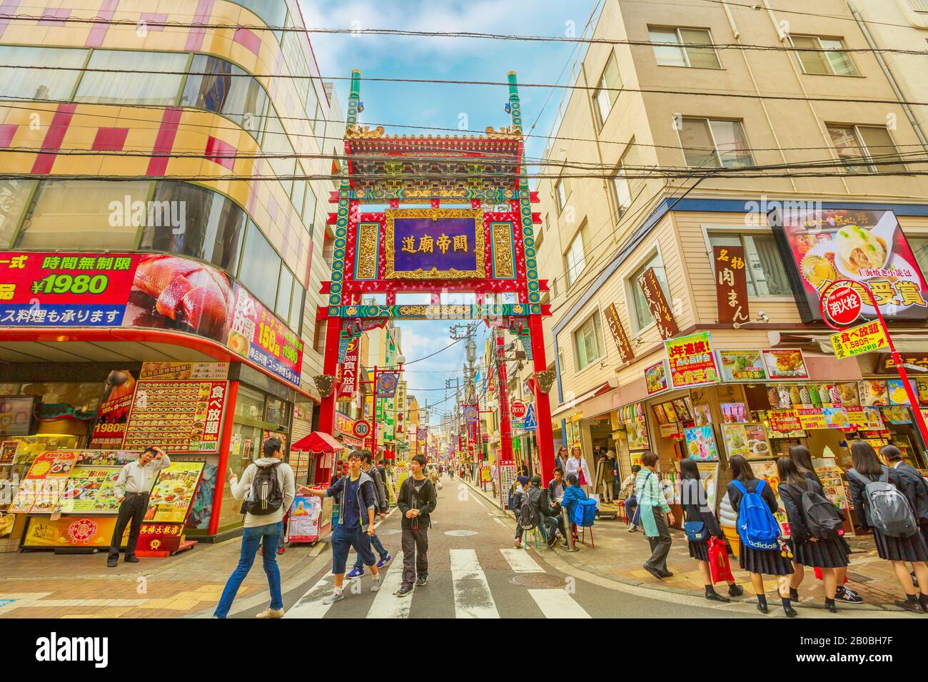 Yokohama, Giappone - 21 aprile 2017: Persone e ragazze asiatiche in uniforme scolastica di fronte al cancello di Yokohama Chinatown, la Chinatown più grande del Giappone Foto Stock