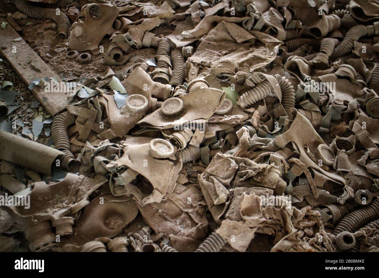 Un mucchio di maschere a gas dell'era sovietica in un edificio abbandonato a Pripyat, in Ucraina, sede del desaster nucleare di Chernobyl del 1986. Foto Stock