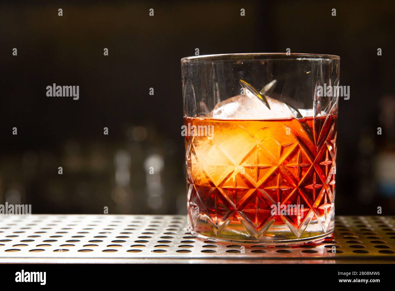 Whisky con una palla di ghiaccio in un bicchiere. Pronto a mangiare. Foto Stock