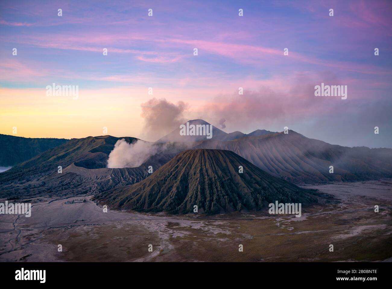 Paesaggio vulcanico all'alba, fumo vulcano Gunung Bromo, con il Monte Batok, Mt. Kursi, Monte Gunung Semeru, Parco Nazionale Bromo-Tengger-Semeru, Java Foto Stock