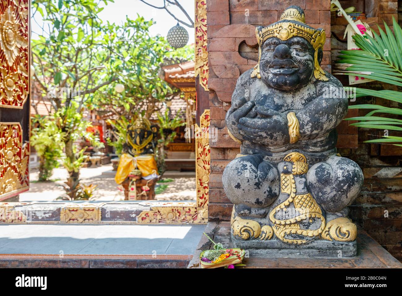 Porte d'ingresso al tempio indù con porte intagliate in legno e statua del guardiano dvarapala. Canggu, Badung, Bali. Architettura tradizionale e classica Balinese. B Foto Stock