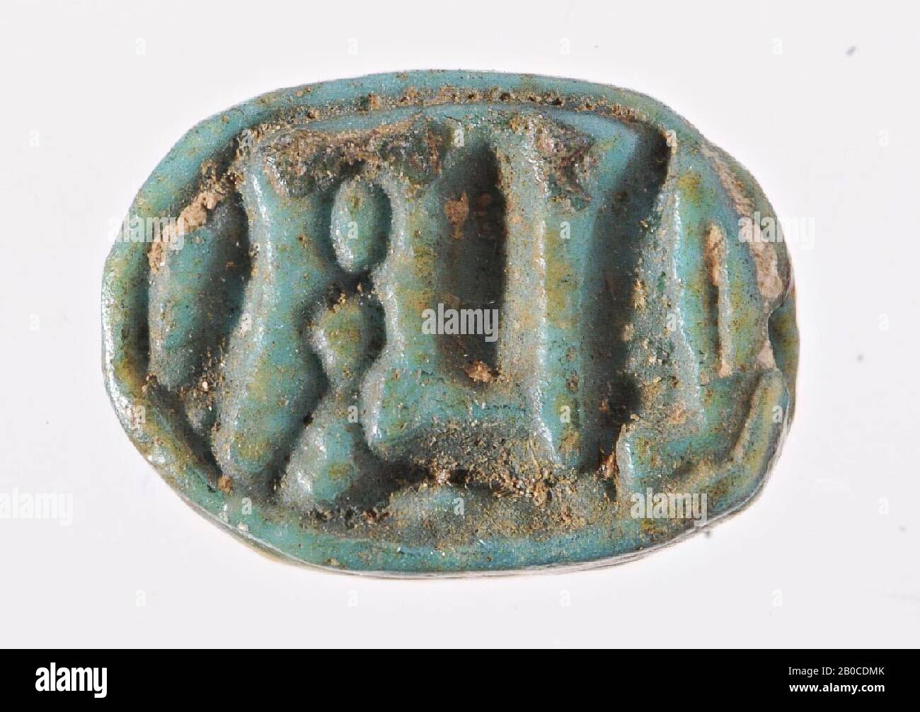 Scarabeo, Ptah, il sigillo ha la forma di una sciarpa stilizzata. La testa a forma di clampano con clypeus e corpo è separata da una linea dentellata. I bordi del corpo sono decorati da una linea tratteggiata a sinistra e da una linea continua a destra. Lo scarabeo è separato dalla sua base ovale da una doppia scanalatura orizzontale intagliata in entrambi i lati. Nel piano ovale di sigillo il nome di dio Ptah è scolpito tra due piume di Maat. Il tutto è incorniciato da una scanalatura singola. L'oggetto è perforato longitudinalmente, sigillo, scarabeo, verde Foto Stock